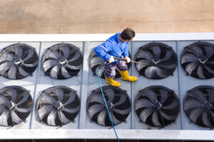 Technician checking commercial HVAC system to improve IAQ HVAC performance
