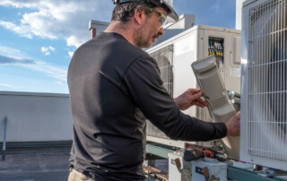 Technician checking commercial HVAC system to improve IAQ HVAC performance