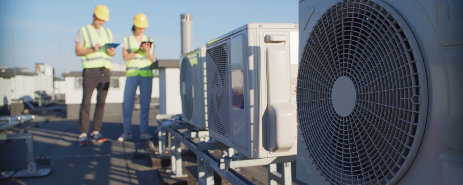 Technician checking commercial HVAC system to improve IAQ HVAC performance
