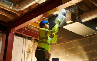 Technician performing duct cleaning training on an HVAC system.