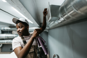 Technician performing duct cleaning training on an HVAC system.
